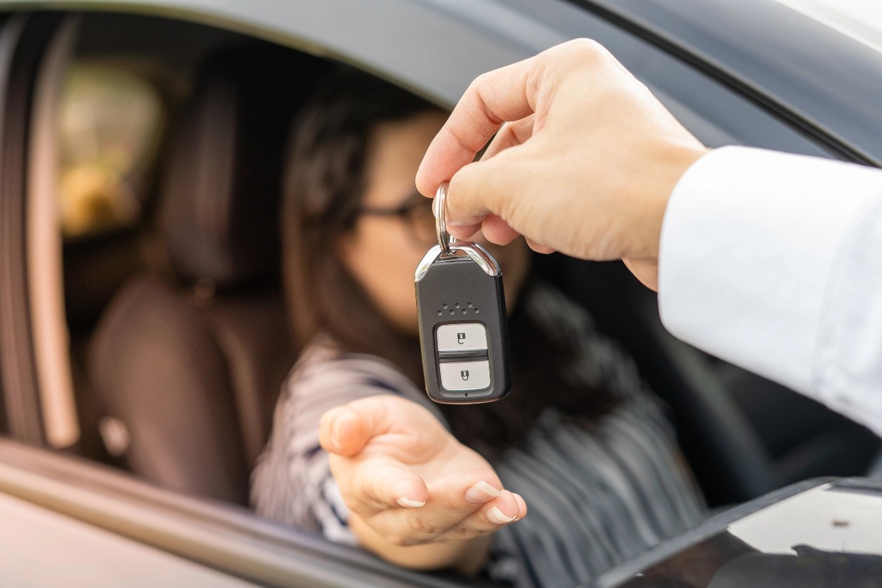 femme dans une voiture qui recoit une clé